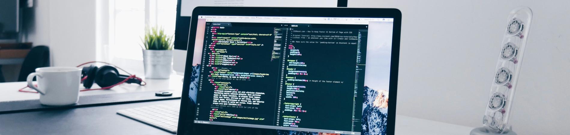 Laptop with code on screen in a bright office setting.